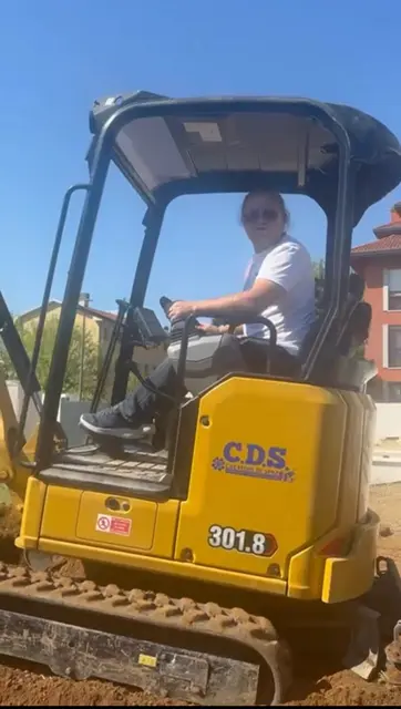 Operatore alla guida del mini escavatore CAT 301.8 con livrea C.D.S.